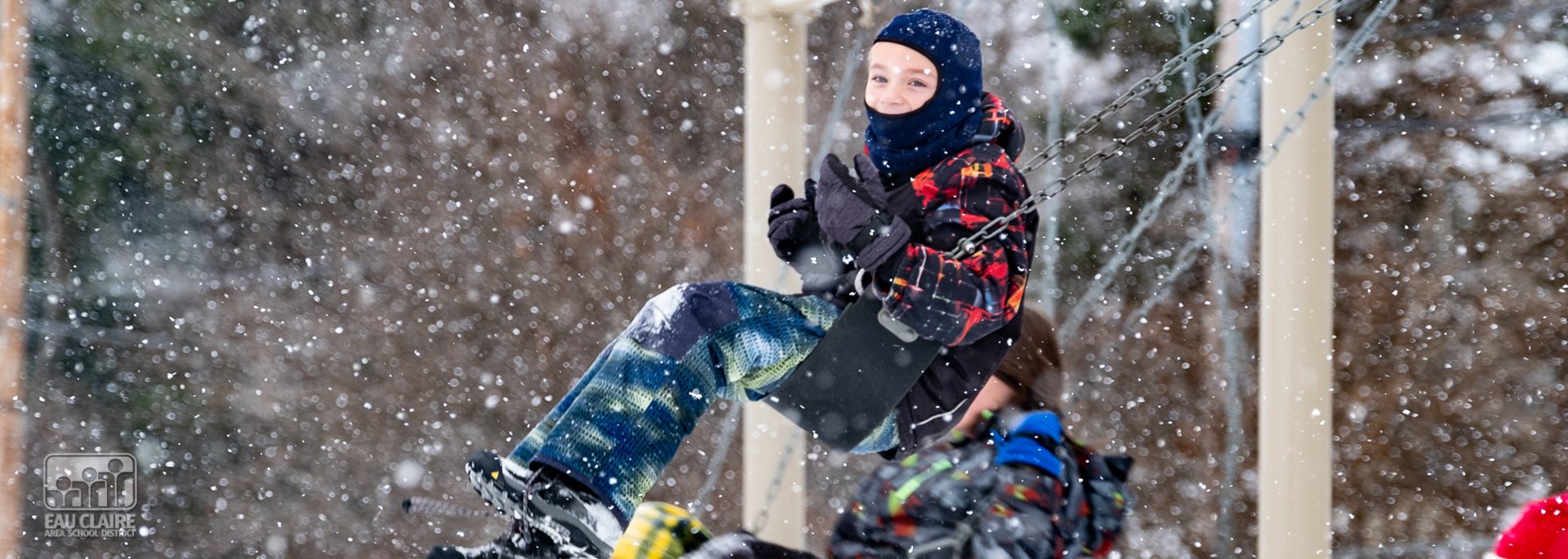 student in snow swinging